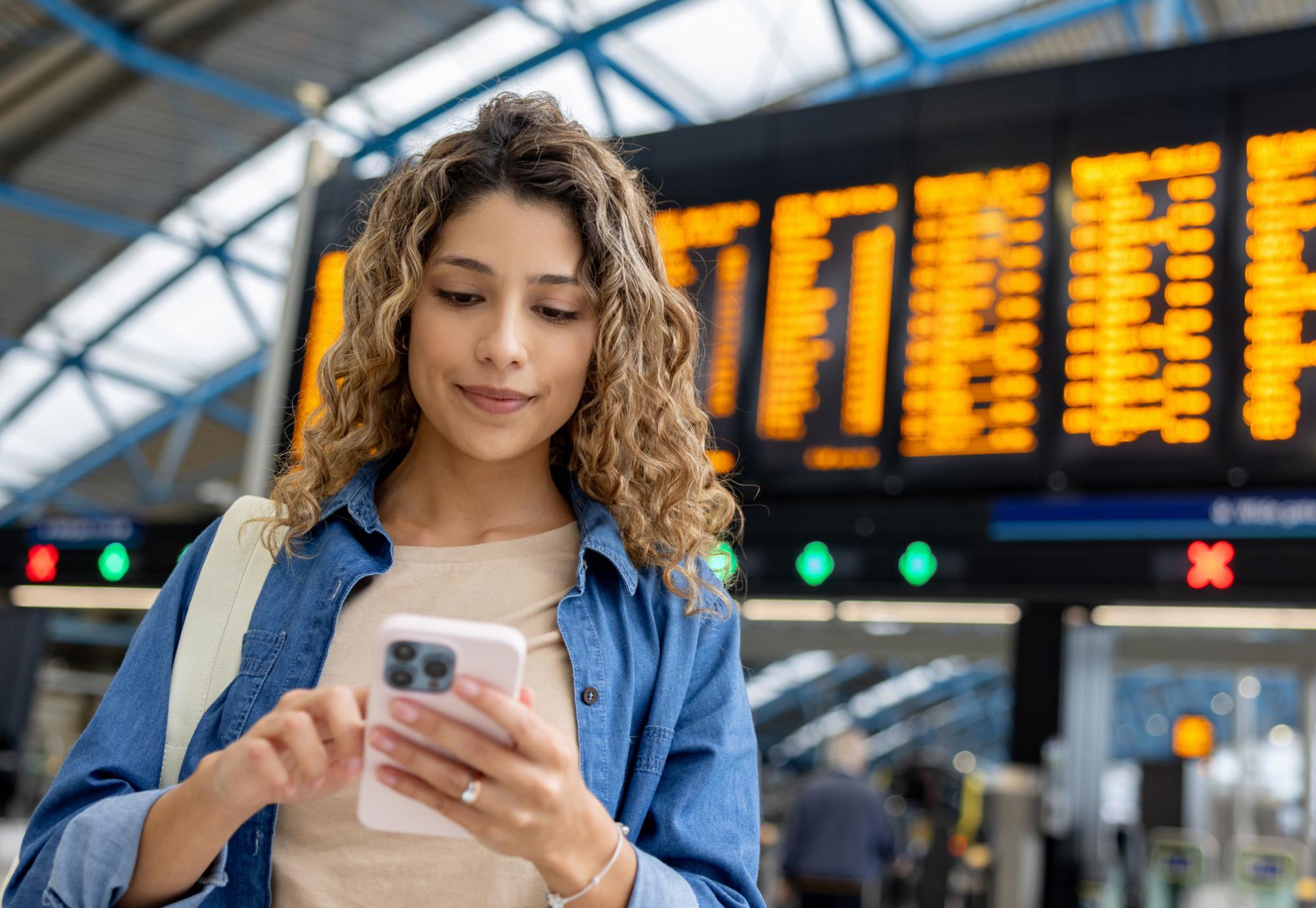 Girl with phone at train station