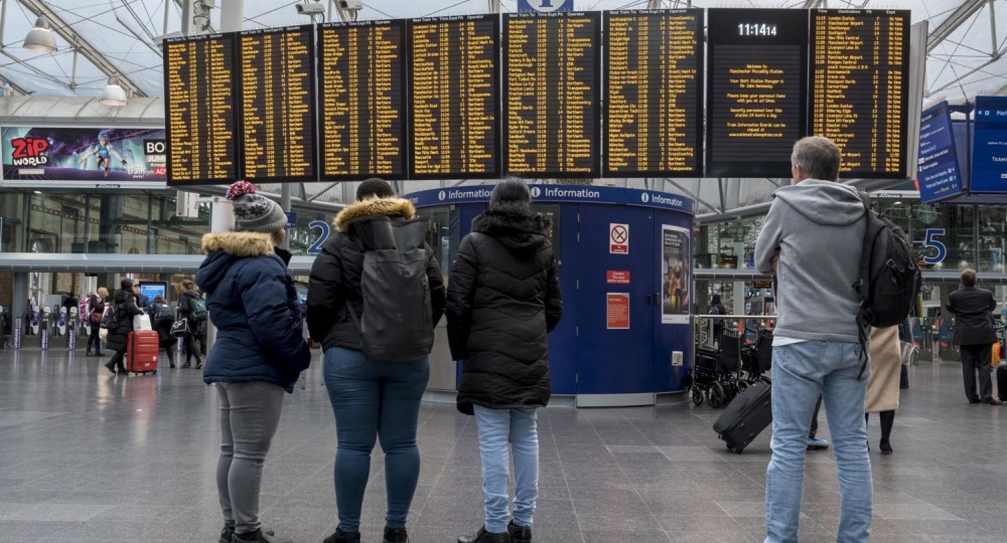 passengers looking at info board 