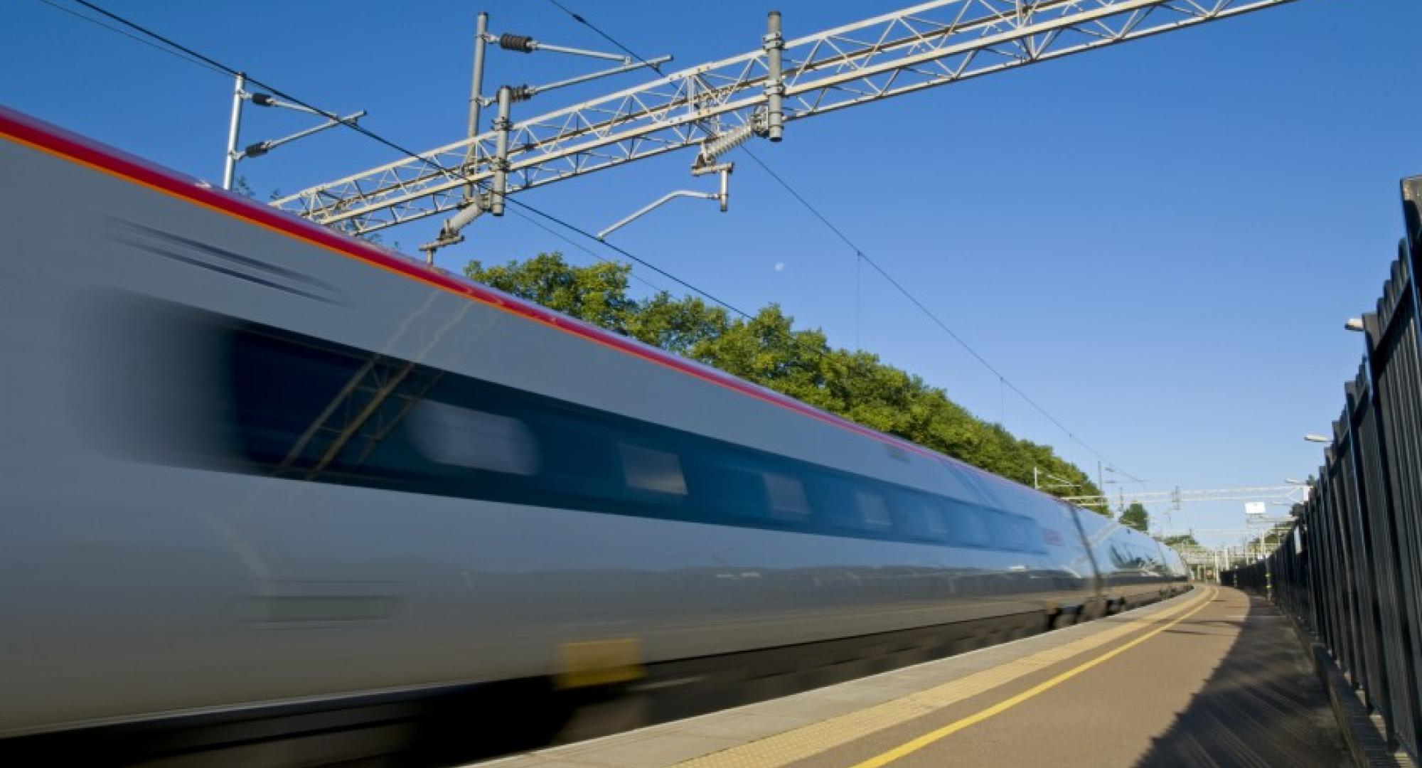 A British high speed passenger train passing through a station in the early morning