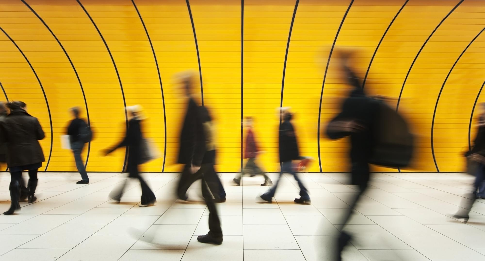 Commuters wlaking past on a train platform