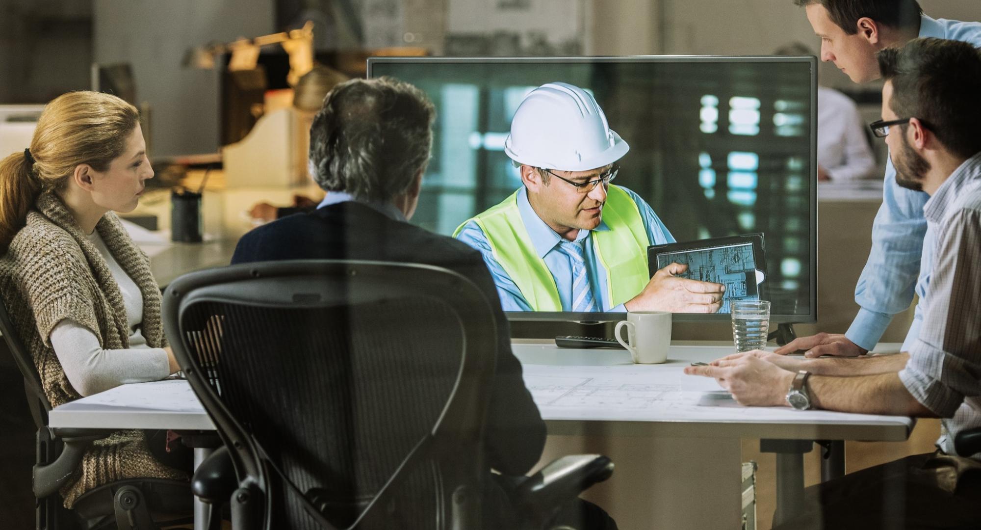 On site engineer discussing with academics in a meeting room