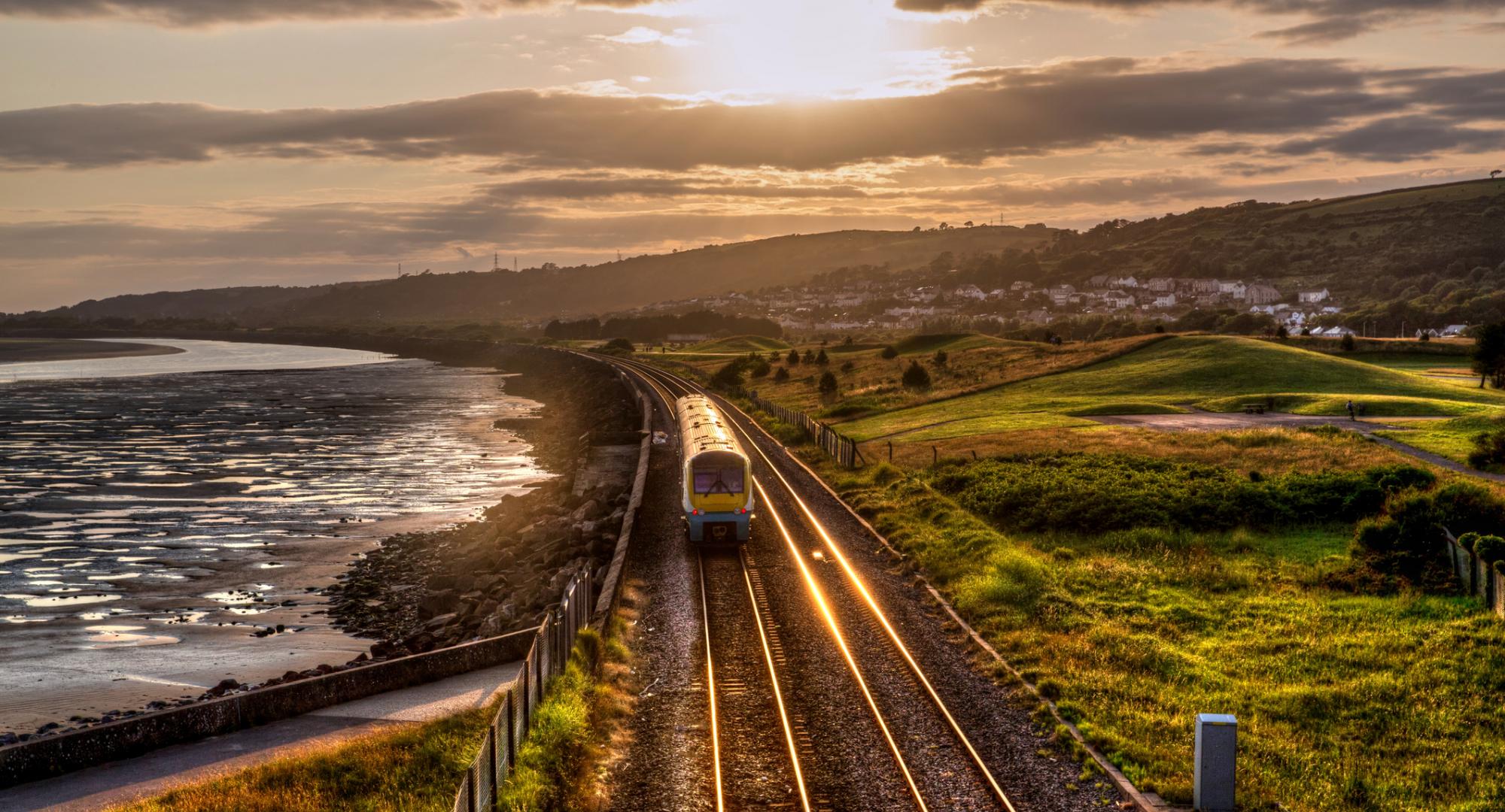 Train travelling through the countryside at sunset in Wales