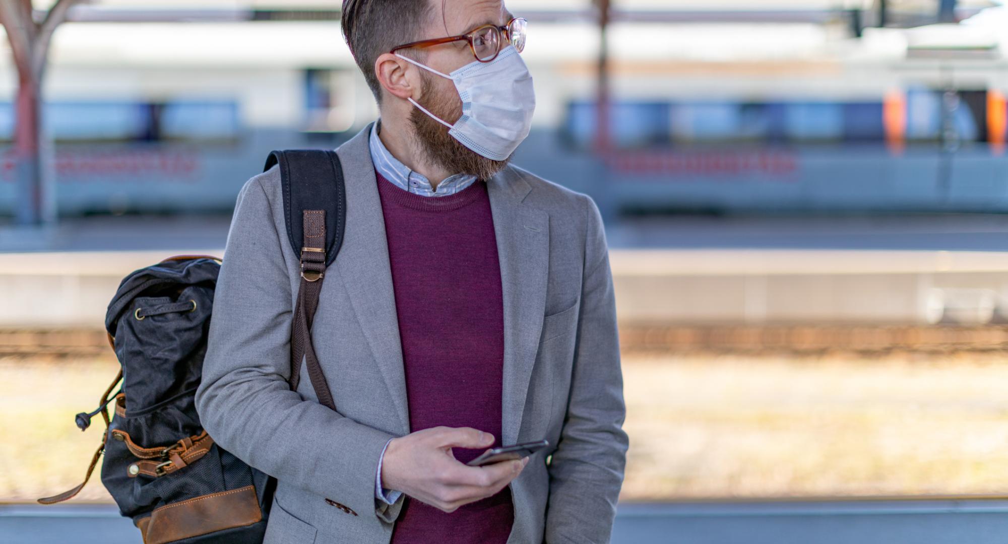 Passenger at a train station with phone