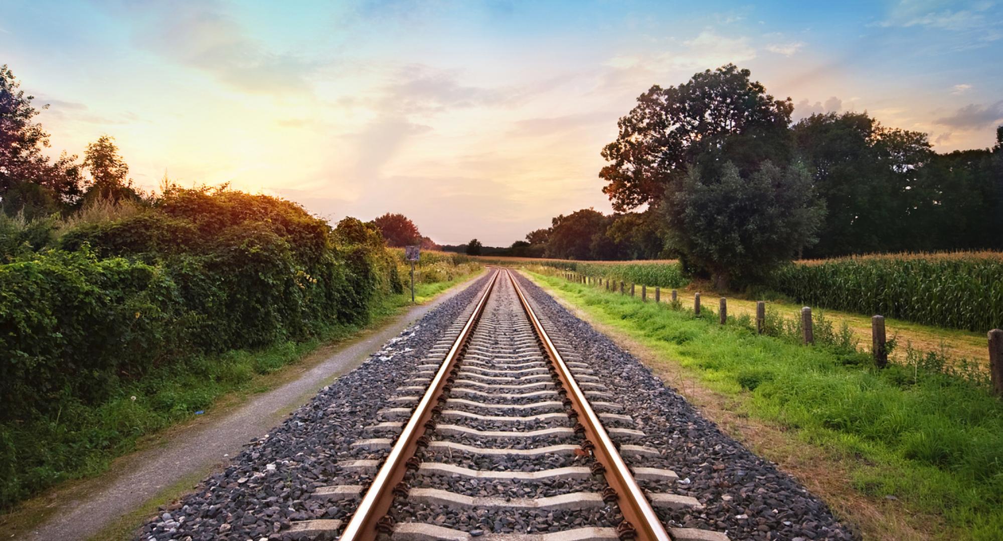 railway tracks in a rural scene with nice pastel sunset, via Istock 