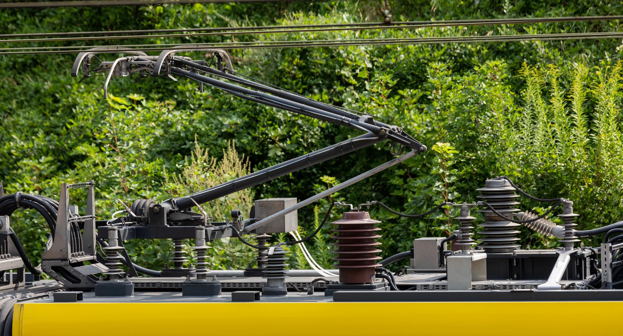 Electric train trolley pole, railway electrification system, overhead rig to supply energy for electric vehicle, via Istock 