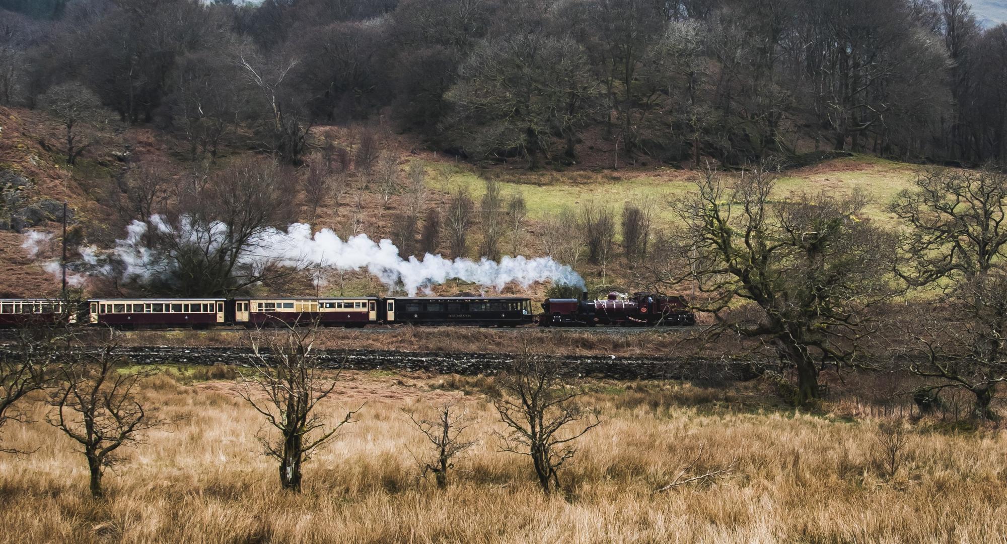 A steam train passing through the small village of Beddgelert, North Wales, via Istock 