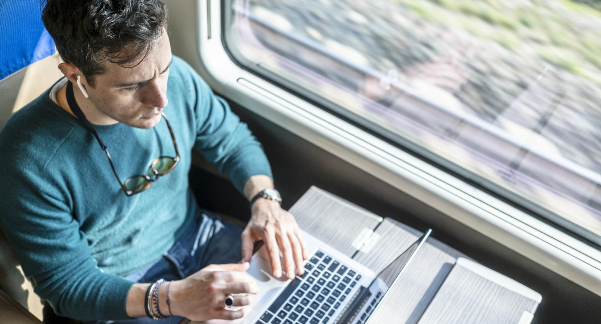 Man utilising internet connectivity on the train, via Istock 