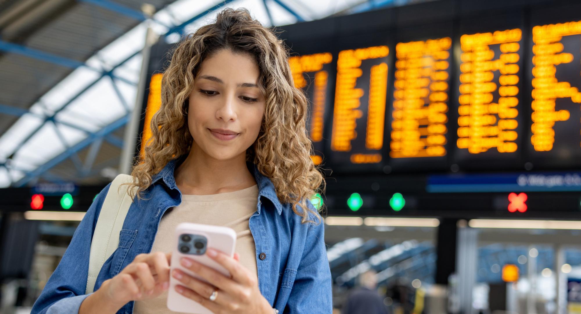 Girl with phone at train station