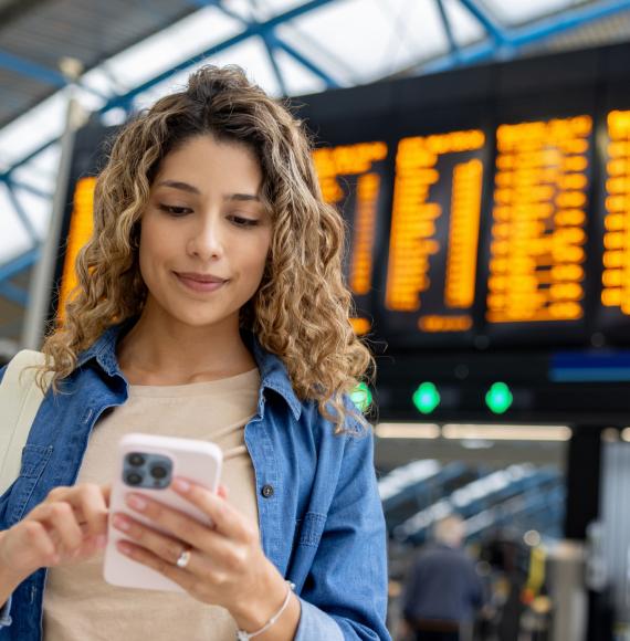 Girl with phone at train station